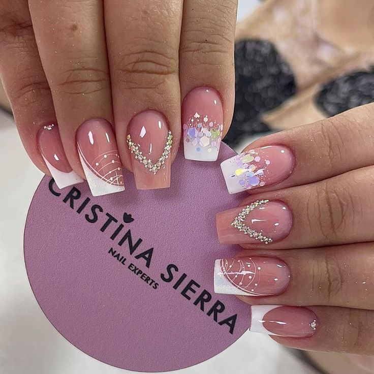 Elegant Soft Pink French Tip Nail Design with Sparkling Gems and Playful Accents.