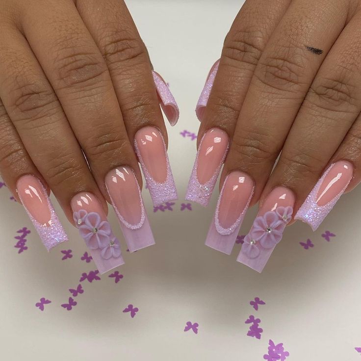 Charming Elegant Nail Design: Soft Pink Base with Glitter Tips and Floral Accents.