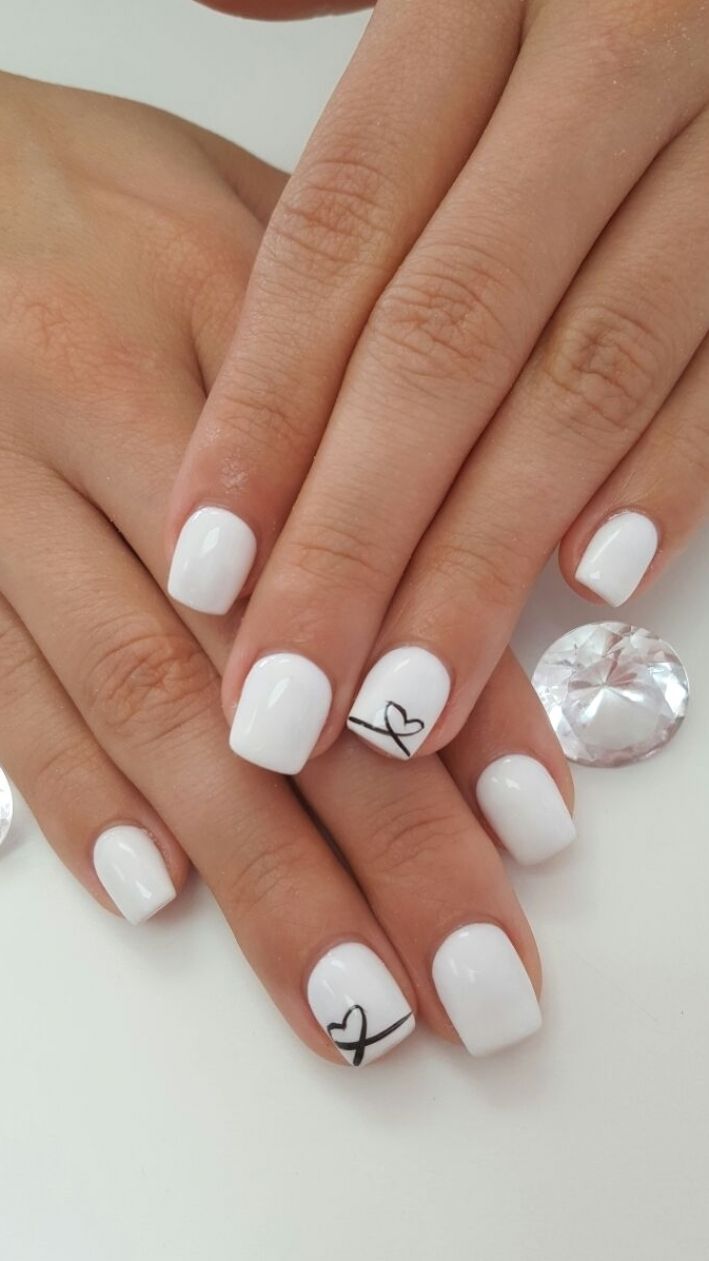 Sleek White Nail Art with Minimalist Black Heart Accent for Elegant Versatility.