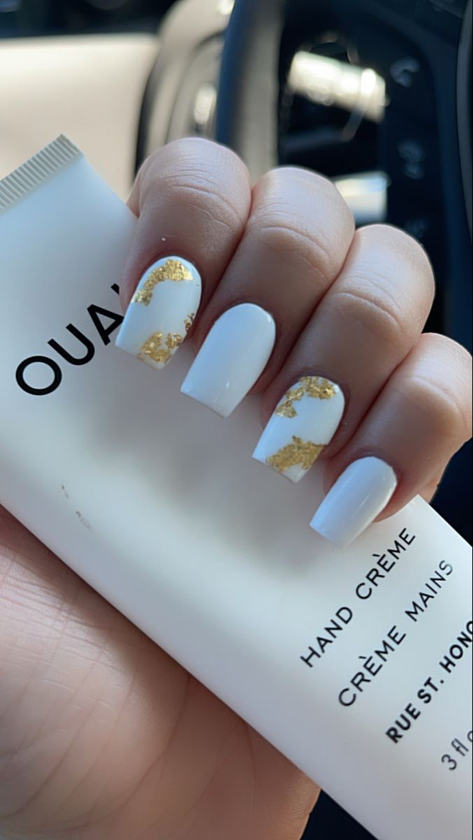 Chic White Nails with Gold Leaf Accents: A Modern Elegance for Any Occasion.