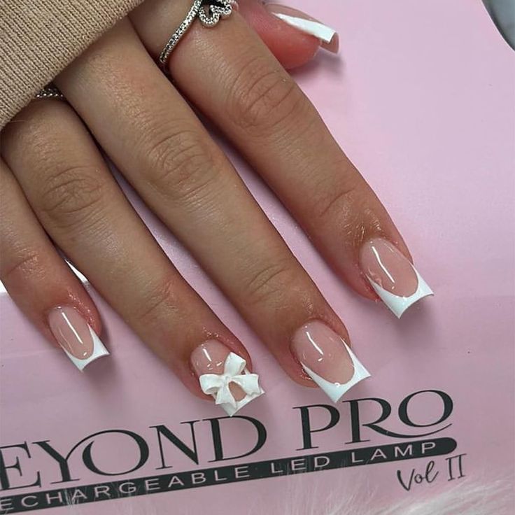 Chic Elegant Manicure: Natural Base with White Tips and Playful Bow Accent.