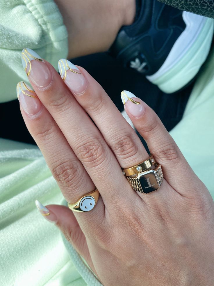 Chic French Manicure with Delicate Gold Stripes and Stylish Ring Accents