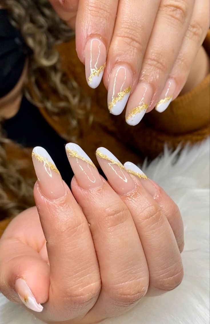 Chic Glamorous French Tip Nail Design with Pale Pink Base and Gold Accents.