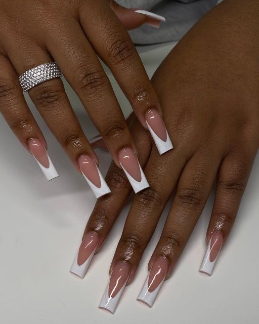 Elegant French Manicure with Nude and White Tips Accented by a Shimmering Ring.