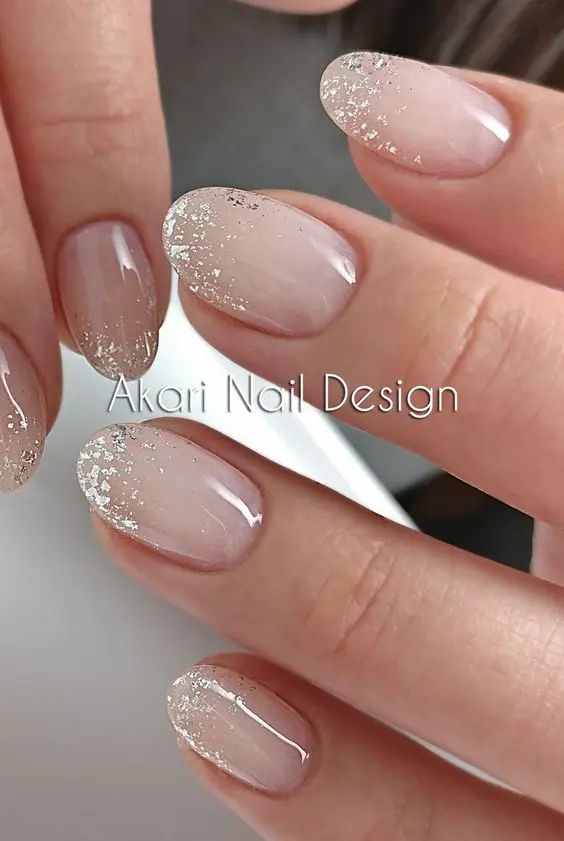 Sophisticated Ombre Nail Design with Subtle Nude Base and Glittery Tips