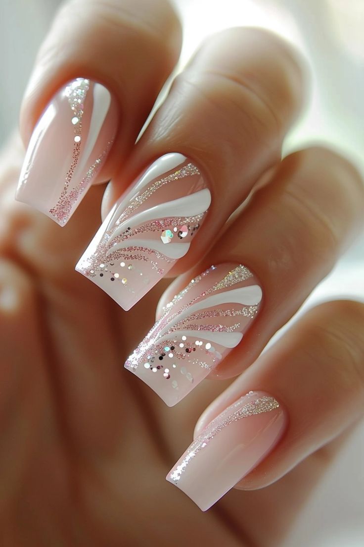 Sophisticated Soft Pink Nail Design Embellished with Elegant White Swirls and Glamorous Glitter.