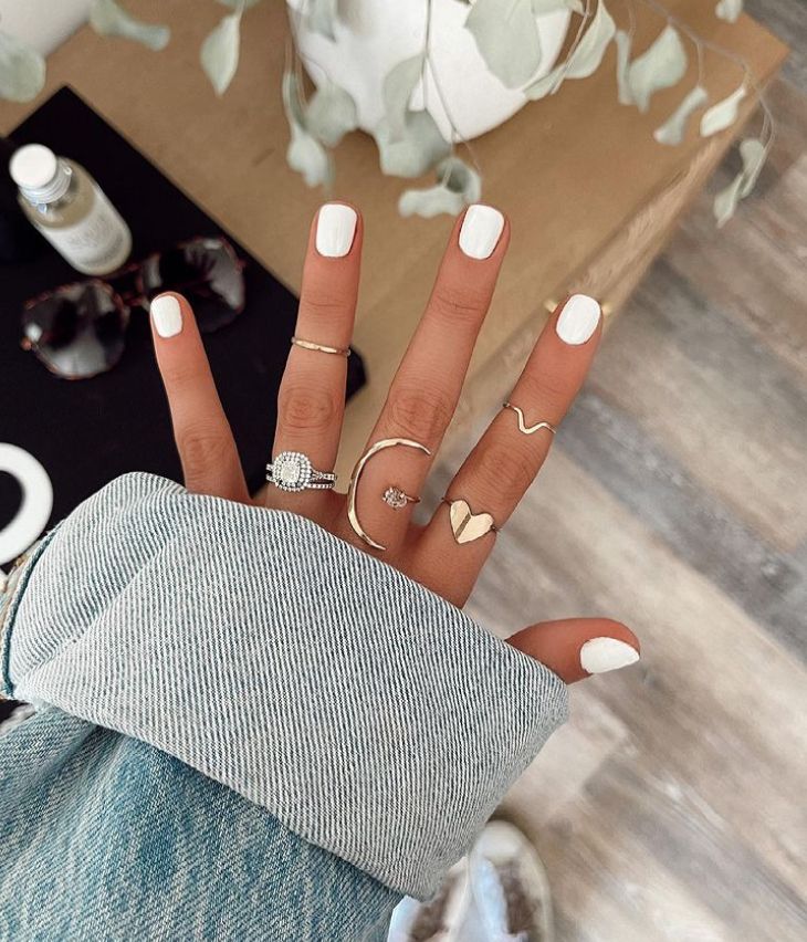 Elegant Minimalist Chic: White Nail Design with Gold Rings.