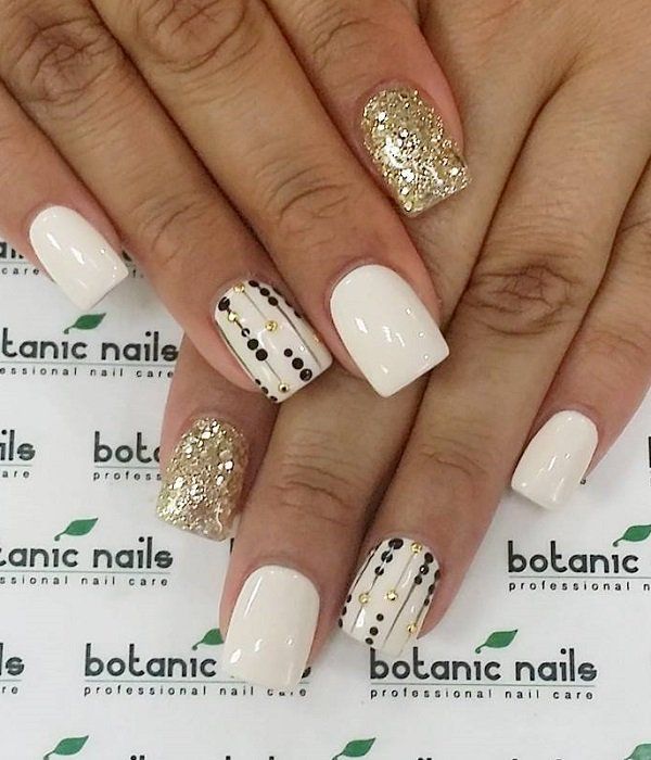 Chic Creamy White and Gold Accented Nail Design with Black Dot Stripes.