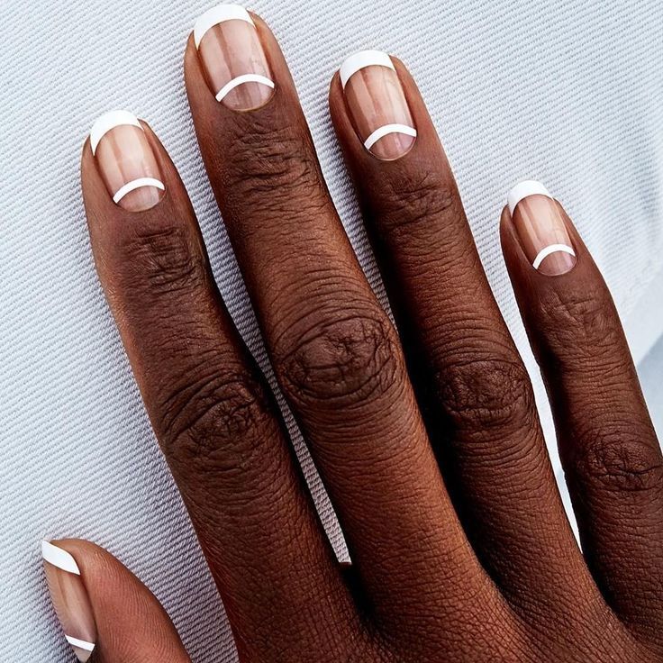 Minimalist French Tip Nail Design: Elegant Nude Base with Delicate White Arcs.