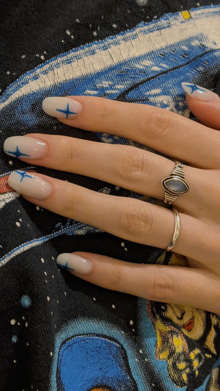 Elegant Ombre Nail Design with Celestial Blue Accents and Understated Jewelry.