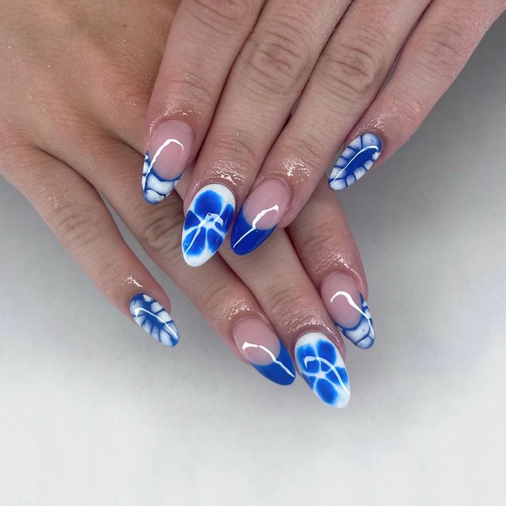 Chic Bold Blue and White Nail Design with Abstract Floral and Geometric Patterns.