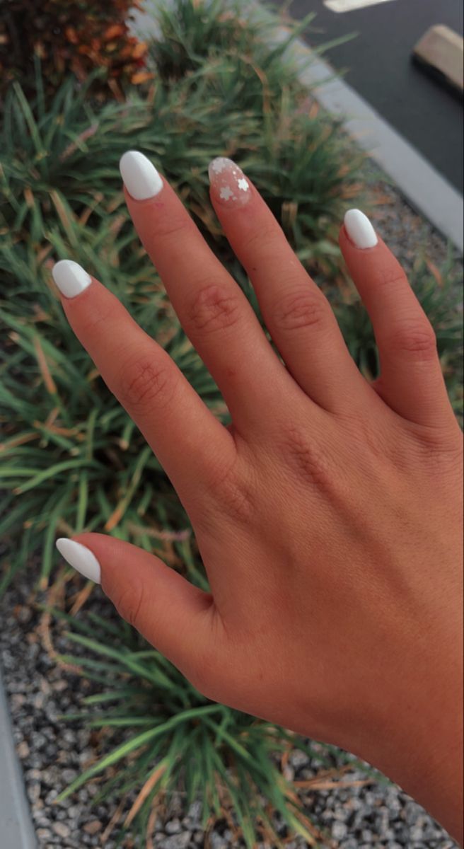 Chic Almond-Shaped White Nail Design with Floral Accent for a Stylish Minimalist Look.