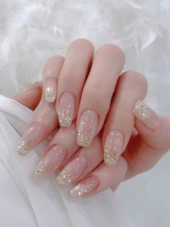 Sophisticated Ombre Nail Design with Sparkling Golden Tips for Glamorous Occasions.