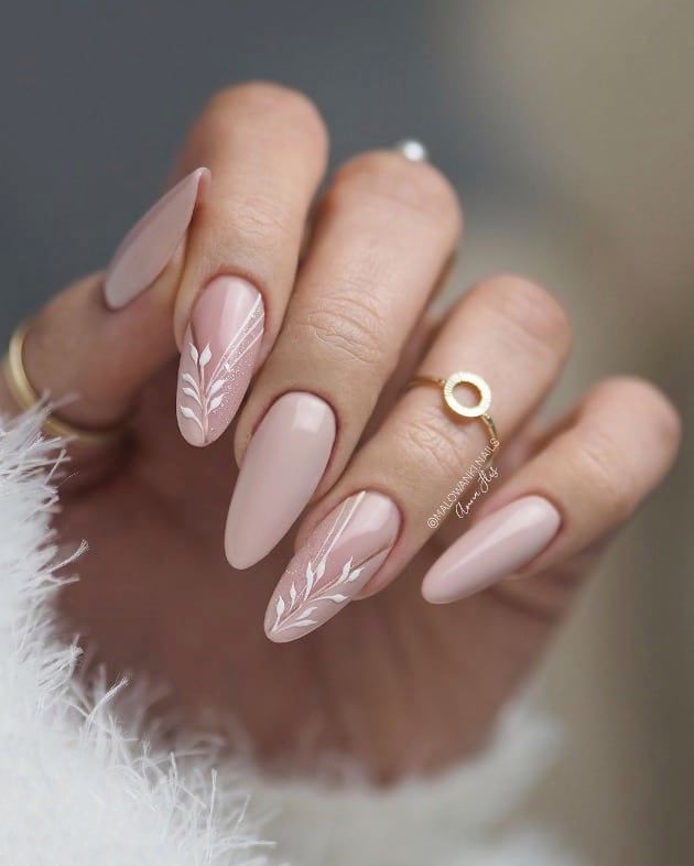 Chic Almond-Shaped Nails with Whimsical Floral Accents in Soft Nude Palette.