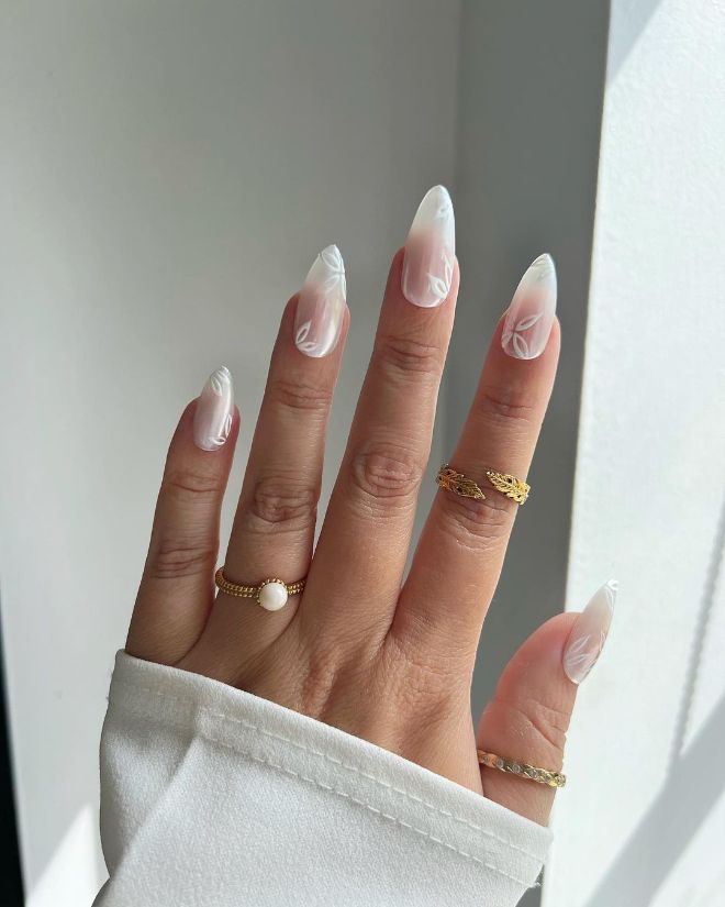 Chic Almond-Shaped Ombre Nail Design with Artful Swirls and Gold Accents