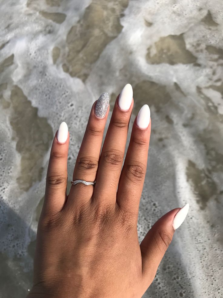 Chic Almond-Shaped White Nails with Sparkling Silver Accent for a Glamorous Look.