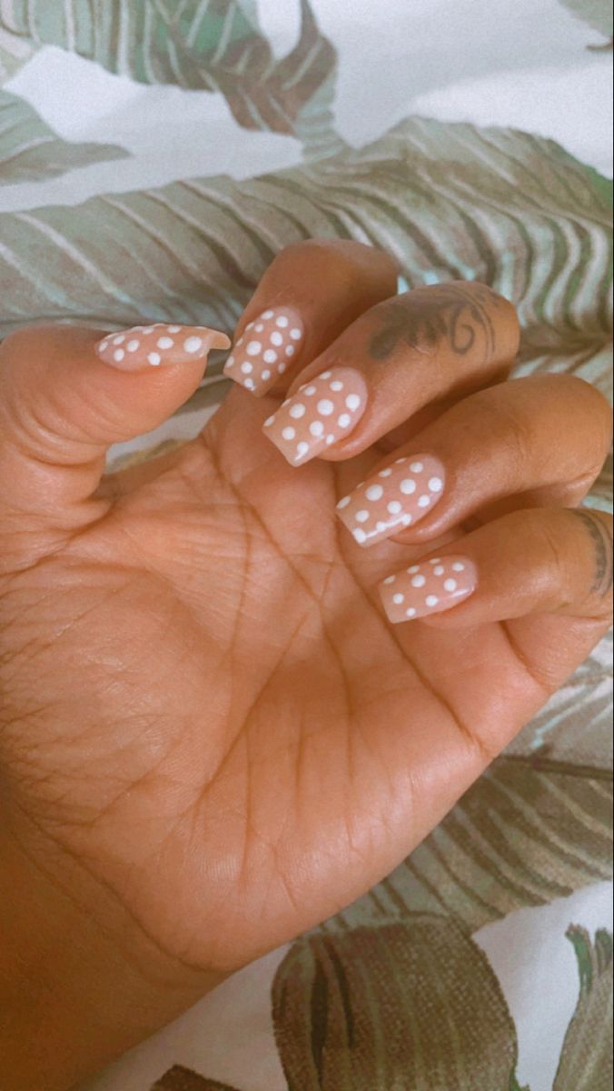 Whimsical Soft Pink Nail Design with Playful Polka Dots for a Charming Touch.