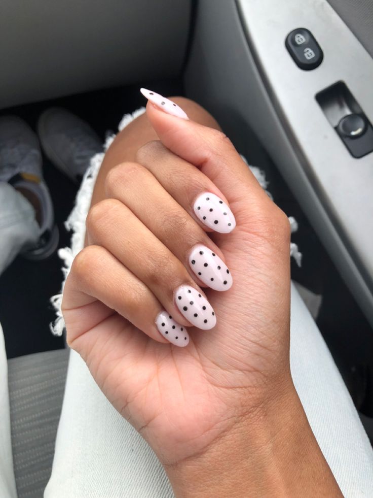 Elegant Almond-Shaped Nails with Chic Nude Base and Playful Black Polka Dots