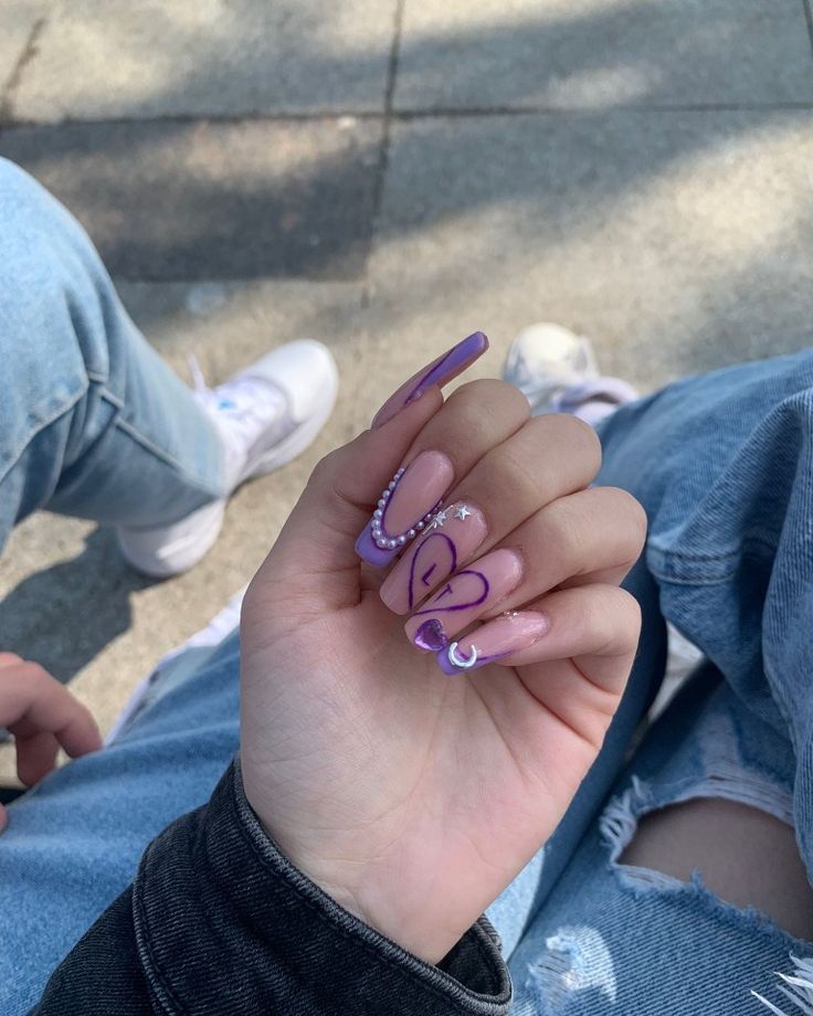 Chic Colorful Nail Art: Long Tapered Design in Lavender and Pink with Heart Patterns and Gem Accents.