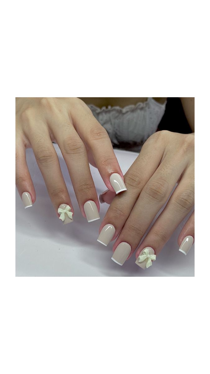 Sophisticated Nail Design with Soft Nude Base and Charming White Bow Accents.