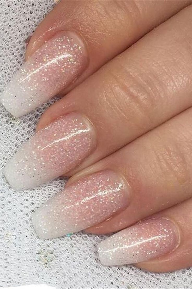 Elegant Ombre Glitter Nails: Soft Pink to White Transition with Sparkling Accents.