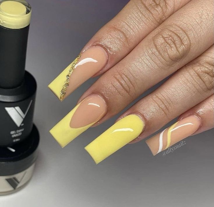 Chic Nail Design: Soft Nude and Vibrant Yellow with Elegant Gold Accents.