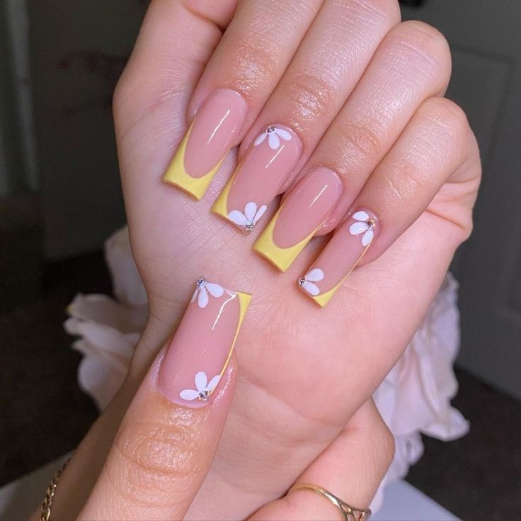 Chic Nude and Pastel Yellow Nail Design with Floral Accents for a Sunny Aesthetic.