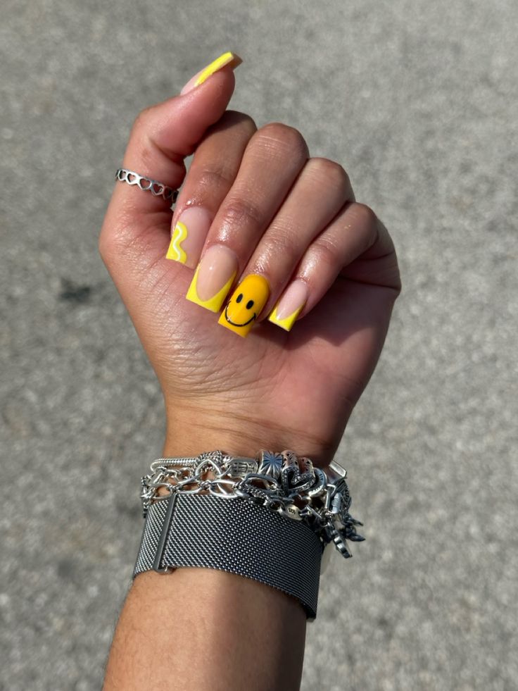 Vibrant Summer Nail Design: Cheerful Yellow with Smiley Faces and Whimsical Zigzag Patterns.