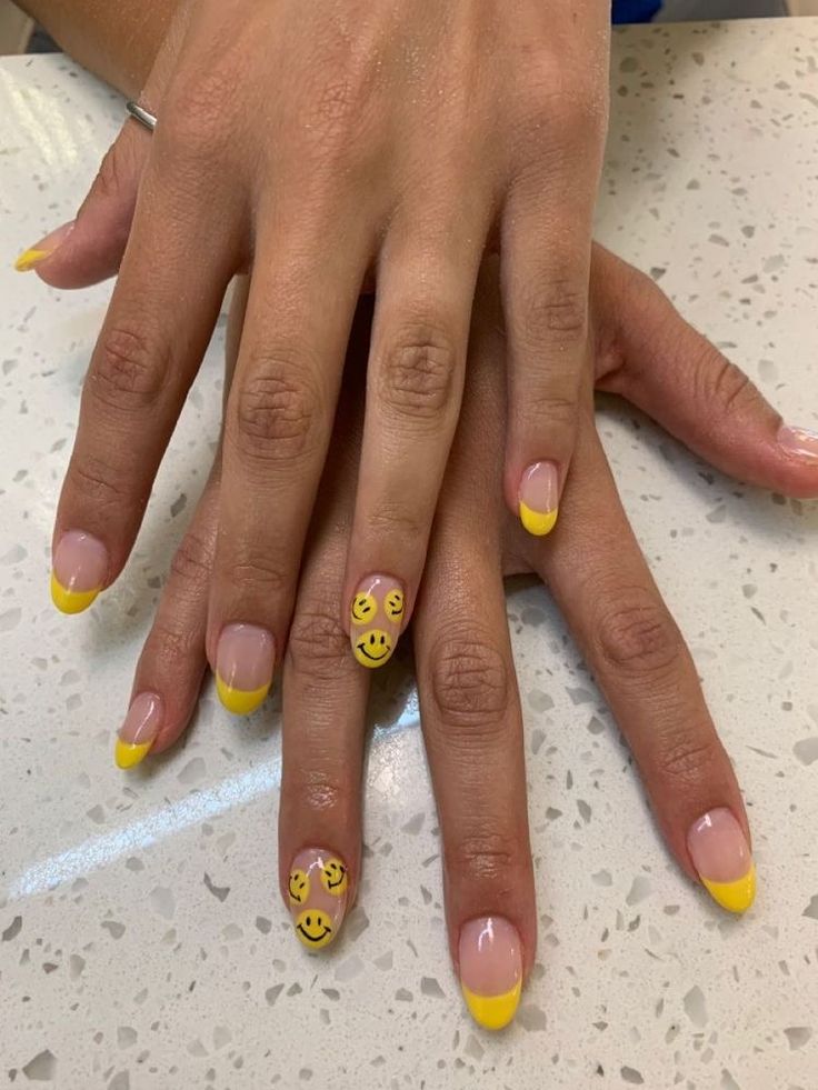 Cheerful Summer Nail Design: Bright Yellow French Tips with Whimsical Smiley Face Accents.