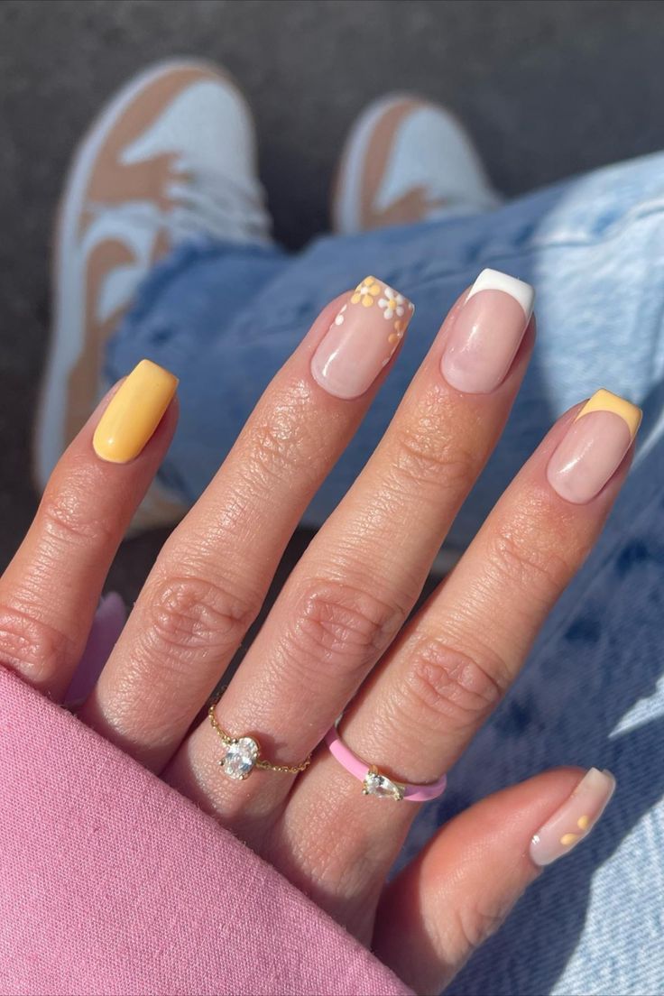 Playful Yet Elegant Yellow, Nude, and White Nail Design with Unique Embellishments.