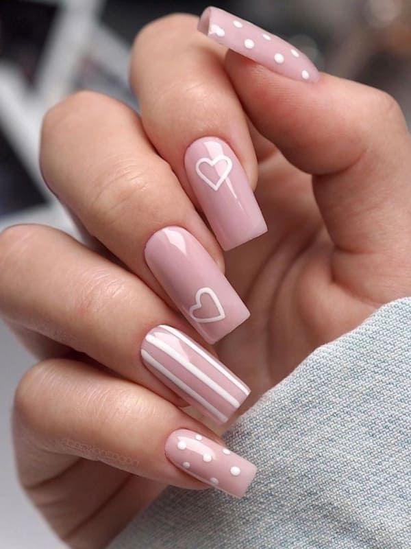 Whimsical Soft Pink Nail Design with Heart Motifs and Polka Dots