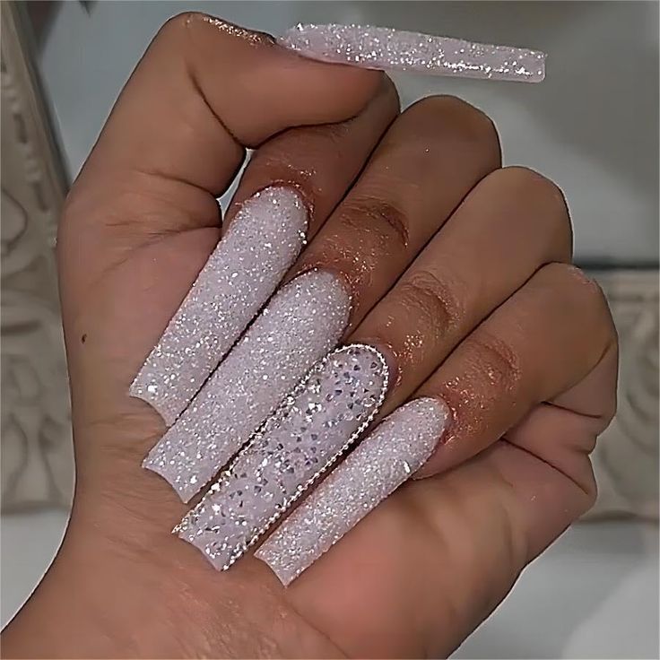 Glamorous Long Glittering Nails in Shimmering White and Silver for Special Occasions.