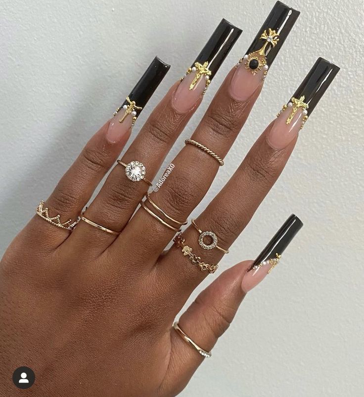 Elegant Black and Nude Nail Art with Gold Accents and Rings for a Bold Aesthetic.