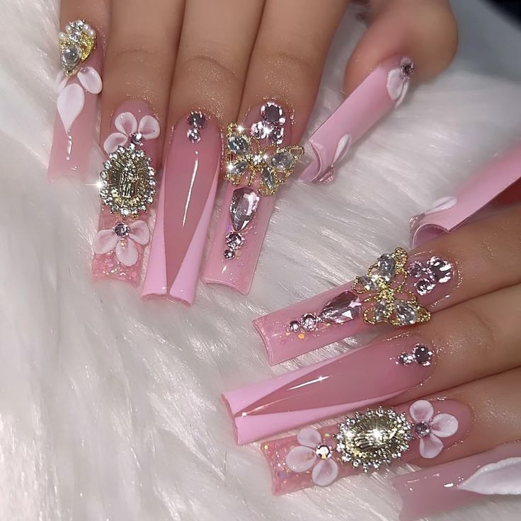 Elegant Pink Manicure with Intricate Embellishments and Floral Accents for Special Occasions.