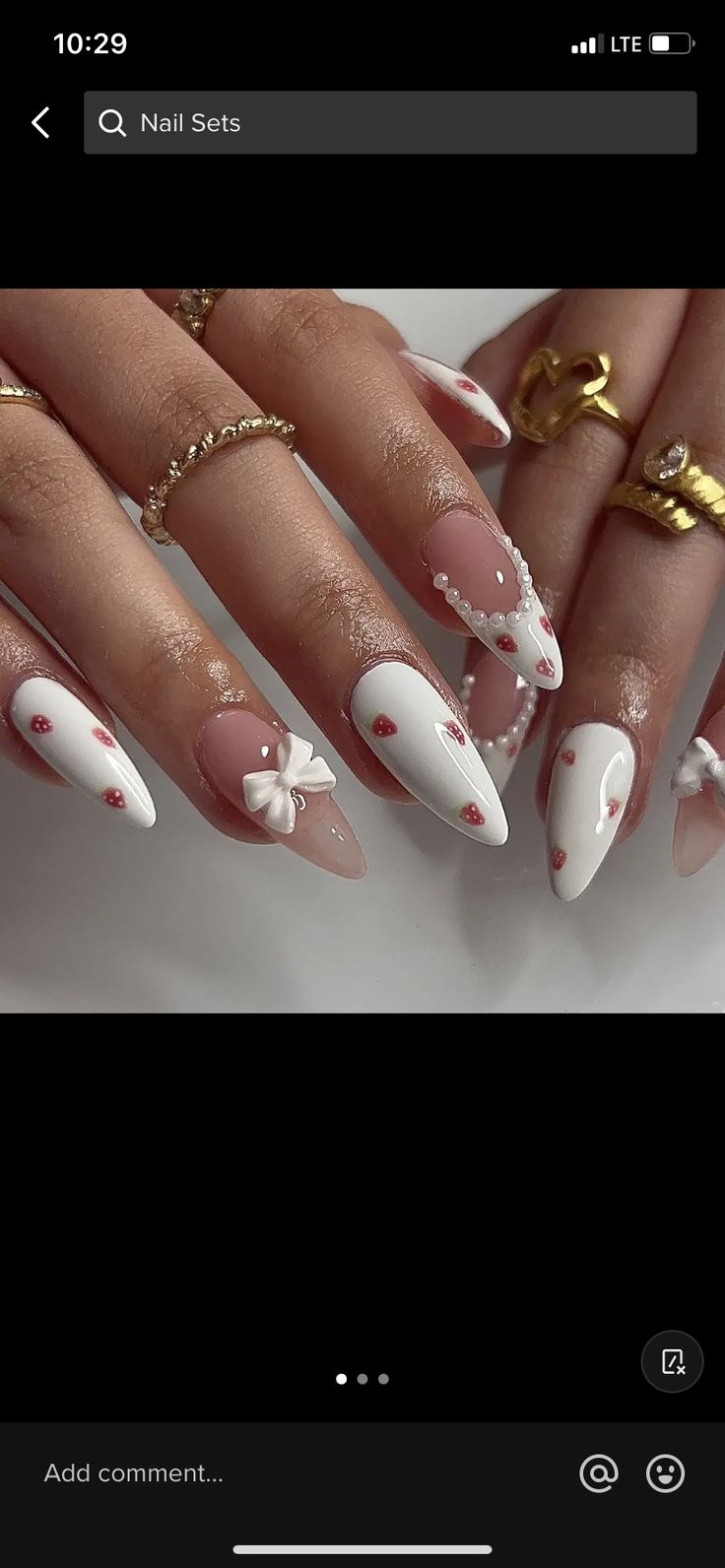 Chic Almond-Shaped Nail Design with White, Soft Pink, Floral Charms, and Glamorous Pearls