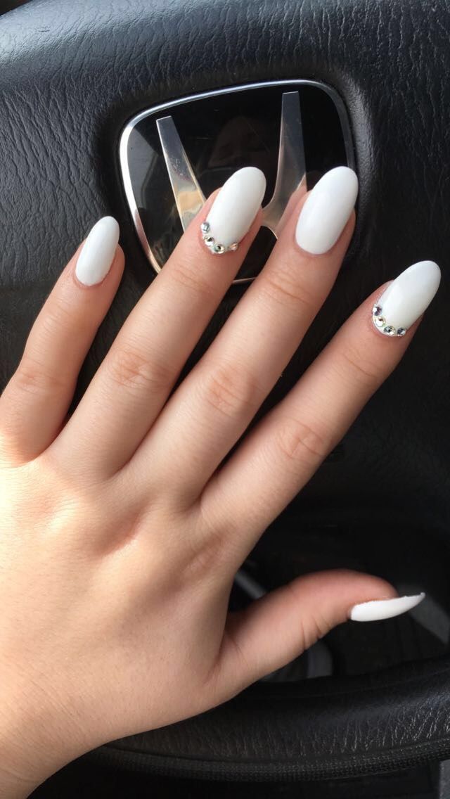 Chic White Almond-Shaped Manicure with Rhinestone Accents for Sophisticated Glamour.