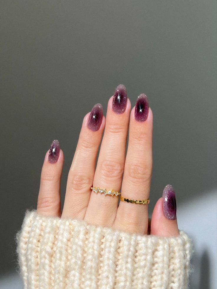 Elegant Ombre Nail Design: A Celestial Gradient from Deep Purple to Soft Pink with Glistening Stars and Gold Accents.