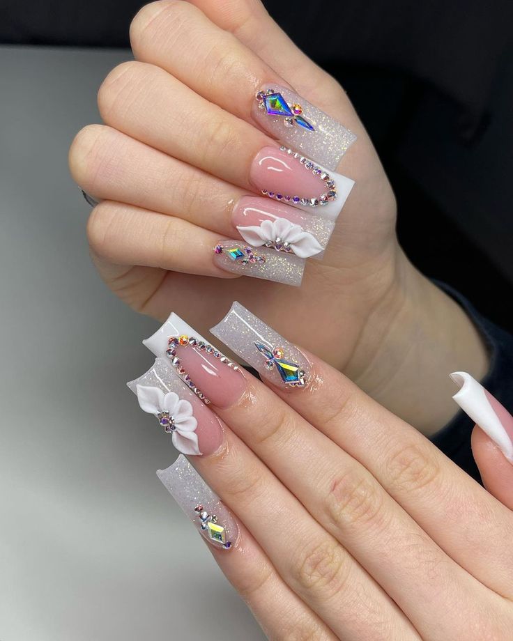 Sophisticated Long Square Nail Design with Shimmering Silver, Floral Embellishments, and Gem Accents.