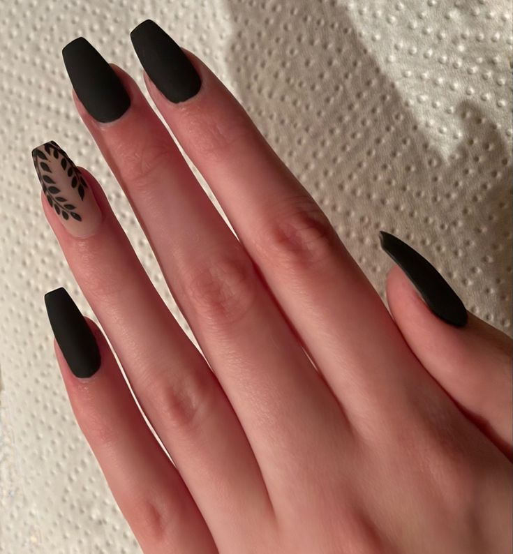 Chic Matte Black Nails with Artful Negative Space and Leaf Accent Design.