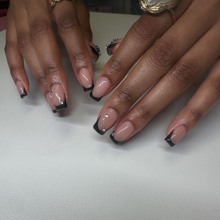 Chic Black French Tip Design on Elegant Nude Nails for a Sophisticated Look.