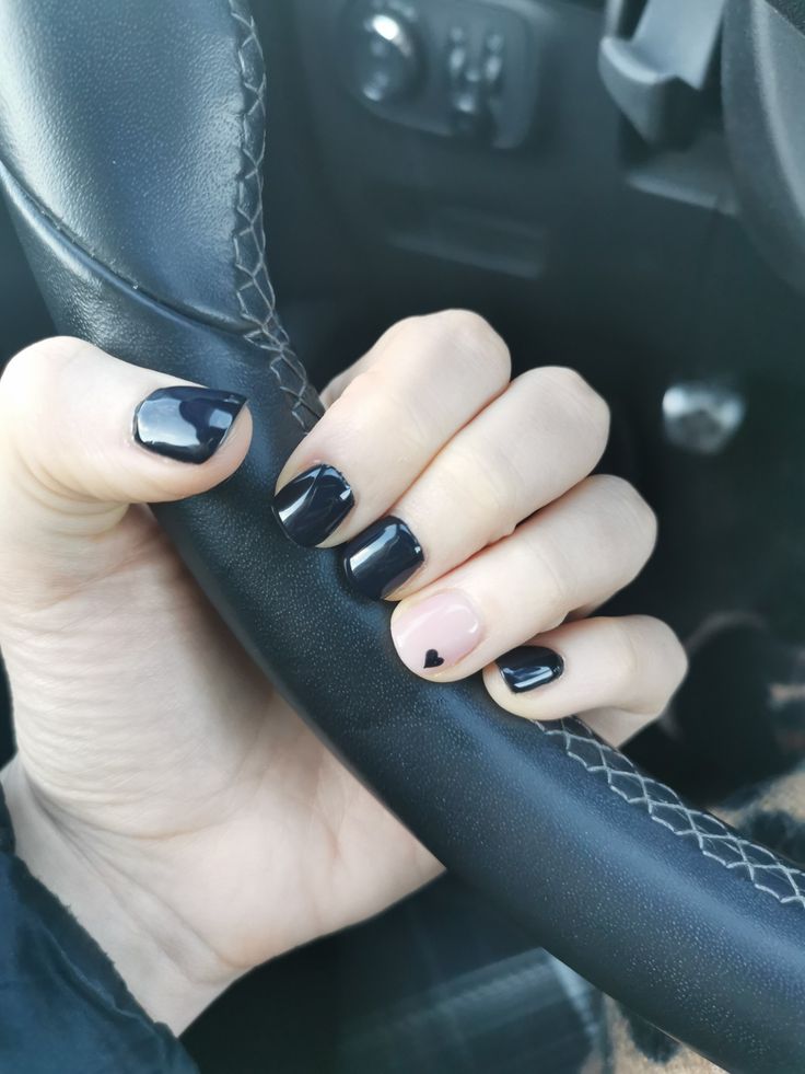 Chic Nail Design: Glossy Black and Soft Nude with Heart Accent