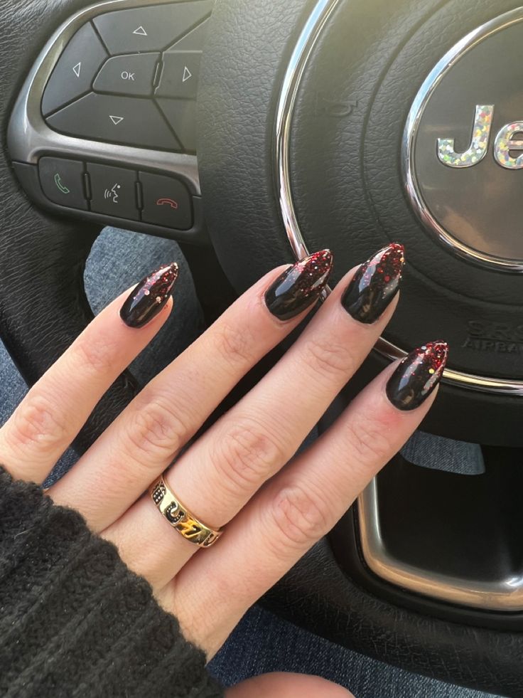 Chic Black and Burgundy Glitter Nail Design with Pointed Shape and Minimalistic Gold Ring.