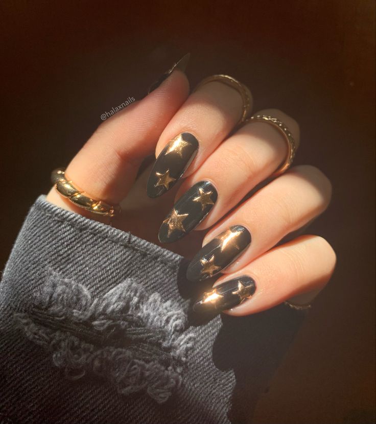 Chic Elegant Black Nails with Metallic Gold Stars and Glossy Finish.