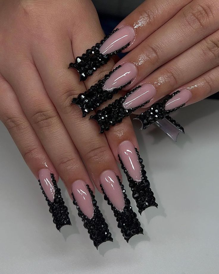 Chic Elongated Stiletto Nails: Soft Pink and Bold Black with Intricate Lace and Sparkling Accents.