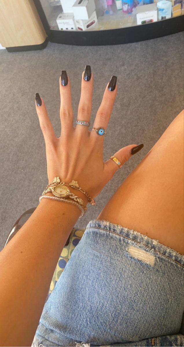 Chic Elegance: Glossy Black Nails Paired with Trendy Accessories for a Stylish Look.