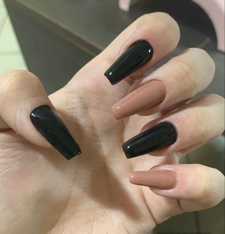 Elegant Stiletto Nail Design: Bold Black and Warm Nude Contrast.