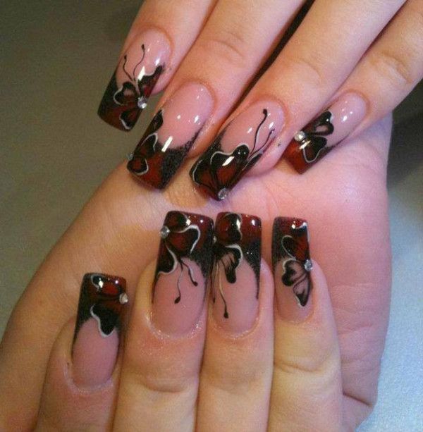 Sophisticated Nail Design: Soft Pink and Bold Black Tips with Butterfly Motifs and Floral Accents.