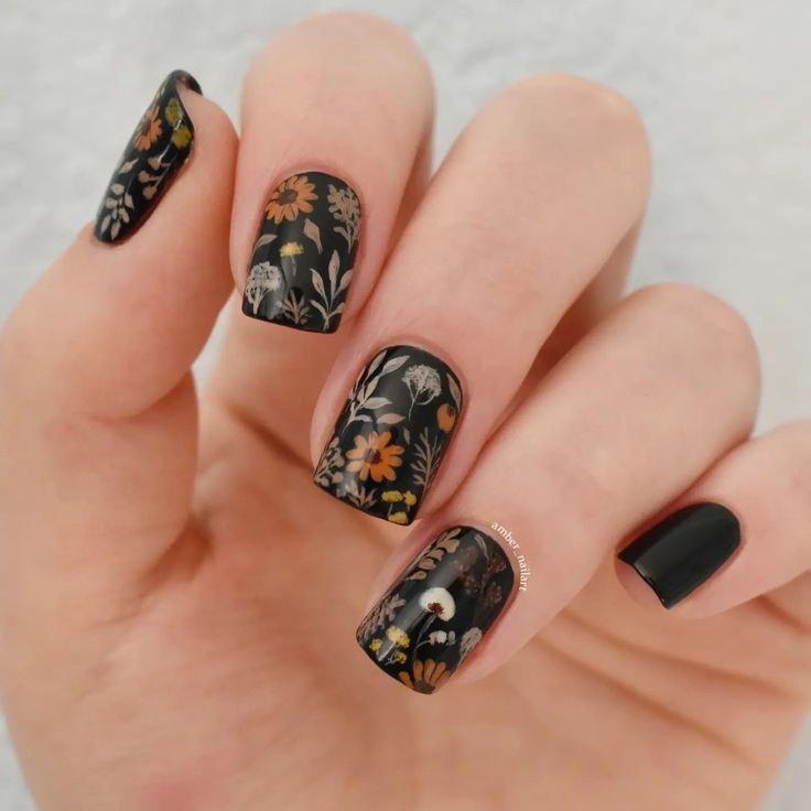 Elegant Floral Nail Design: Vibrant Blooms on a Matte Black Base.