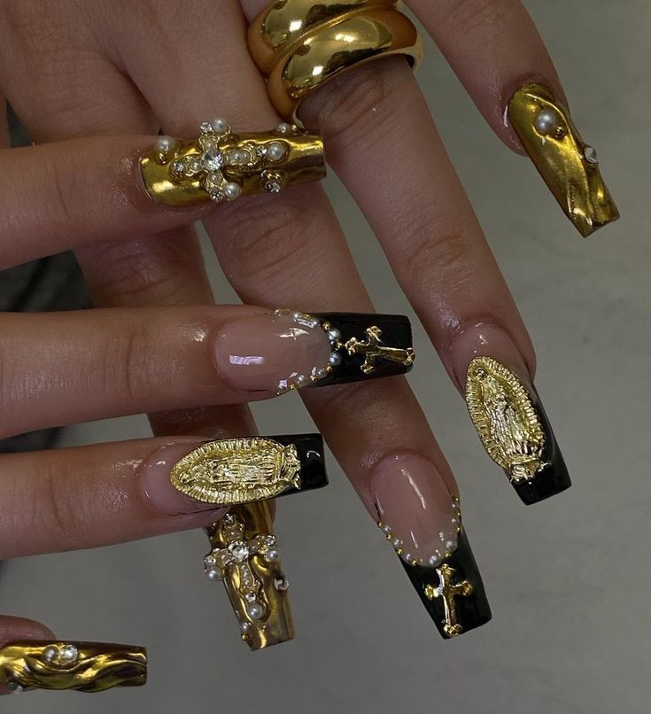 Luxurious Gold and Black Nail Design with Intricate Embellishments and Elongated Shape.