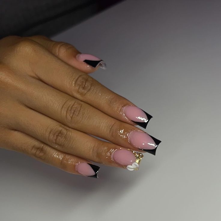 Sophisticated Nail Design: A Glamorous Blend of Soft Pink and Striking Black with Intricate Embellishments.